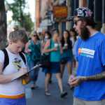 In this June 11 photo, Damian Riniker, right, a marijuana reform advocate with the group NORML, stands by while a passerby signs a petition to get a pot club initiative on the ballot in the next election, in Denver.