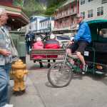 Kristopher McClure of Alaska Pedicab offers his services in front of the Red Dog Saloon in early June.