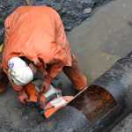 Ed Beam, a laborer with Admiralty Construction Inc., cuts out a corroded section of water main off of Glacier Highway near Point Lena Loop Road.