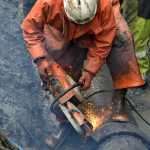 Ed Beam, a laborer with Admiralty Construction Inc., cuts out a corroded section of water main off of Glacier Highway near Point Lena Loop Road.