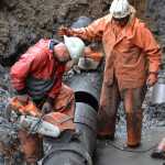 Shaun Lewis (left) and Ed Beam (right), of Admiralty Construction Inc., work to fix a leaking water main off of Glacier Highway. Corrosion ate a hole in the pipe, which was installed in the late '80s.