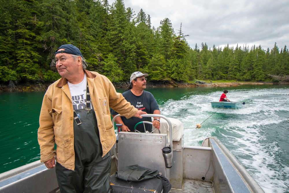 Sam Mooney speeds the skiff around a school of sockeye, hoping to trap salmon in the beach seine attached to the blue dingy. Photo by Bethany Goodrich.