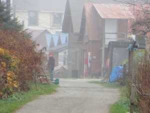People chat in Tenakee Springs on a foggy fall day.