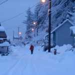 A woman makes her way up a snowy Tenakee Springs Road.