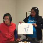 Staff manager and service coordinator for REACH at the Canvas Colleen James holds up one of Grace Coenraad's earlier pieces, many of which incorporated figures. Mary Catharine Martin | Capital City Weekly