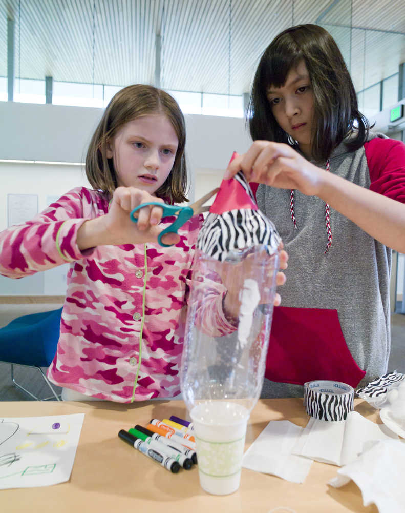 Kate Stickel, 8, left, and Ava Furuness, 11, learn how to make a rocket during Science Friday at the Mendenhall Valley Public Library on Friday. The event was made possible by the Juneau Public Library and the Seattle Museum of Flight.