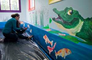 Amanda Falls and her daughter, Le'Neaha DeTienne, paint the inside of a new daycare facility at Pavitt Health & Fitness in July.