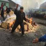 Master carver Wayne Price, apprentice carvers, and Hoonah community members dance around the fire heating the rocks for the second of two forty-foot spruce dugout canoes.