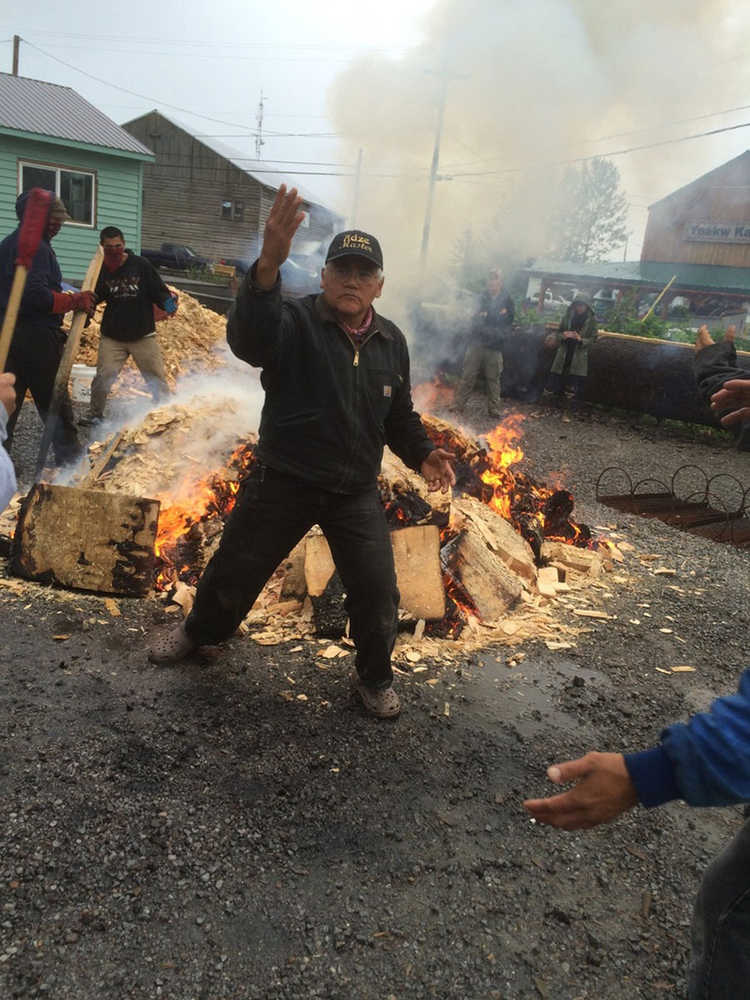 Master carver Wayne Price, apprentice carvers, and Hoonah community members dance around the fire heating the rocks for the second of two forty-foot spruce dugout canoes.