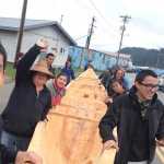 Jerry White, left, takes a selfie with carvers, Hoonah community members, and the newly expanded dugout canoe.