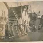 Yakutat in the World War II era, with seal skins drying and a resident hanging an old cotton gill-net.