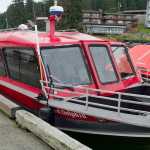 A 25-person inflated life-boat sits next to a Dolphin Jet Boat Tours whale-watching boat tied up at the Statter Memorial Boat Harbor in Auke Bay on Monday. One of the companies boat sunk on the south end of Aaron Island on Sunday. Eighteen people were rescued with one minor injury reported.