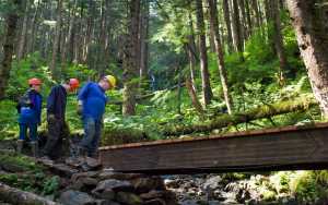 C. Allen Truitt, right, program coordinator of the city's Youth Employment in Parks program, looks over a finished bridge on the Mt. Jumbo Trail with Brandon Jack, 15, left, and Chris Worrell, 18, on Thursday.