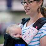 Ericka Beery with her six-month-old daughter, Karinne, attend the Big Latch On at the Dimond Park Fieldhouse on Saturday.