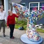 Nancy DeCherney, Executive Director of the Juneau Arts & Humanities Council, receives a decorated six-foot whales tail from Bruce Simonson in front of the Juneau Arts and Culture Center on Friday. The sculpture is one of ten similar whale tails created for a project conceived and funded by Laraine Derr as part of Juneau's fund-raising effort for The Humpback Whale Sculpture at Bridge Park. Simonson used 900 images of historical posters and memorabilia from over 50 arts organizations in Juneau, the oldest is of a production of Thornton Wilder's "Our Town", performed by the Juneau Douglas Little Theatre and the Juneau-Douglas Community College in 1960. To explore an online virtual 3D model of the Tales on the Tail sculpture, visit the JAHC website at:http://www.jahc.org/the-humpback-whale-project.