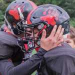 Crimson Bears junior Bubba Stults (left) and sophomore John Hamrick talk strategy during Saturday's game at Adair Kennedy Field.