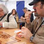 Tourist Mike Edgington bites into a panko-crusted Coho salmon bite at Deckhand Dave's, the second tasting on a Juneau Food Tours tour.