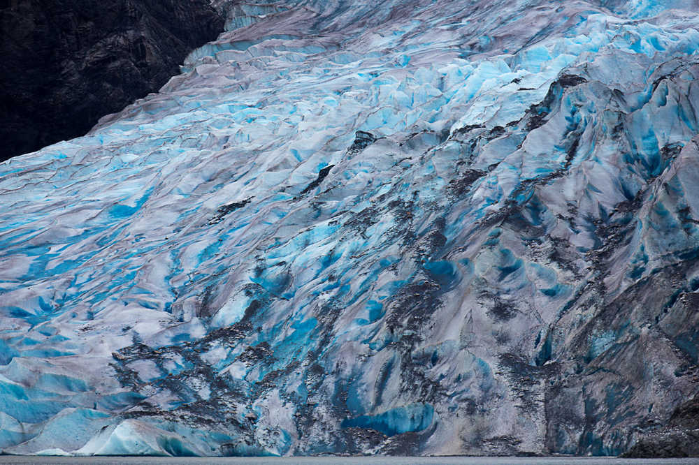 Mendenhall Glacier's blue ice towers over Mendenhall Lake on Aug. 19.