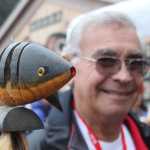 Buddy Howard of Hoonah, raven/coho, poses with regalia in front of Xunaa Shuká Hít.
