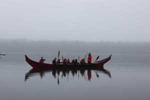 One of the two 40-foot spruce dugout canoes carved in Hoonah by master carver Wayne Price and apprentices Steven Price (Wayne's son), Zack James (Tlél Tooch Tláa.aa) and James Hart (Gooch Éesh) arrives to Bartlett Cove. Around two dozen paddlers made the trip from Hoonah to Glacier Bay in one of three dugout canoes.