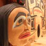 A face on an interior house post in Xunaa Shuká Hít. Each house post represents one of Glacier Bay's four original clans. In the background is the interior house screen.