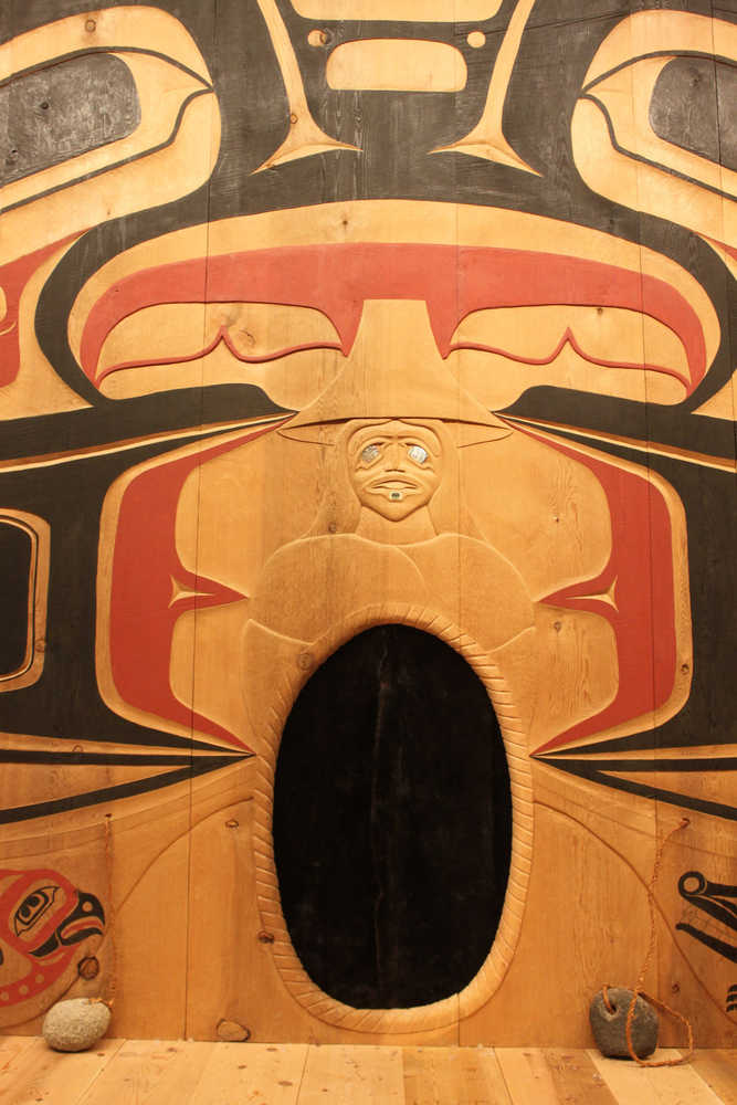 Kaasteen is the central figure in Xunaa Shuká Hít's interior house screen. According to oral history, Kaasteen caused the advance of the glacier that forced the Huna Tlingit to flee Glacier Bay. In some versions of the story, she stayed behind; in others, her grandmother stayed in her place. People gifted her with sea otter furs, hanging over the doorway at center, so she could stay warm. Her eyes are abalone, reflecting the glacier as it advances.