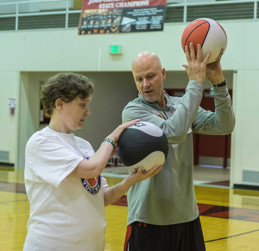 Tammi Birch 38 (left) and former NBA assistant coach for the New York Knicks Greg Brittenham (right) focus on ball handling techniques before taking the shot at "I Did. You Can." Basketball camp for athletes with special needs on Saturday at JDHS Gymnasium.