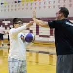 Ben Kriegmont 48 (right) a volunteer for this years "I Did. You Can." Basketball Camp goes to high five Mithcell (left) a participant, after a attempted shot at the basket.