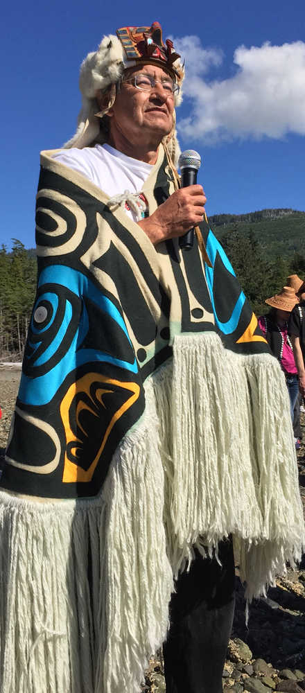 Standing Chief Son-i-Hat, John McAllister, welcomes and grants permission to canoes to land on the beach before Naay i'Waans.