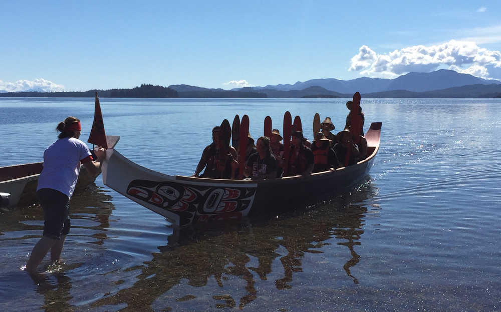 St'igiinii (Harley Holter) greets the canoe from Ketchikan as its paddlers pull into shore.