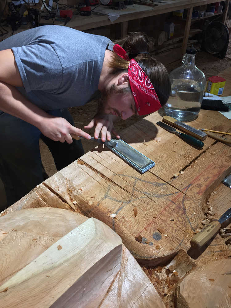 Haida apprentice carver St'igiinii (Harley Holter) works diligently on a totem pole that will be completed later this year.