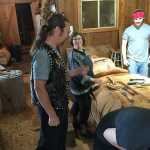 Lead Carver Gitajang (Glenn "Stormy" Hamar) gives instructions to volunteers and carving crew as they work on a totem pole that will be completed later this year.