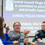 Sgt. Shawn Phelps, right, listens to Teresa Sarabia, center, with Grace Singh and Will Martin, left, watching during the Juneau Police Department's Coffee with a Cop event Tuesday.