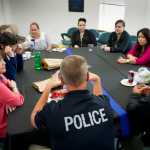 Officer Mike Wise speaks with people attending the Juneau Police Department's Coffee with a Cop event Tuesday.