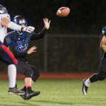 Thunder Mountain's quarterback Owen Mendoza pitches the ball out to running back Roy Tupou during their game against North Pole at TMHS on Friday. TMHS won 22-20