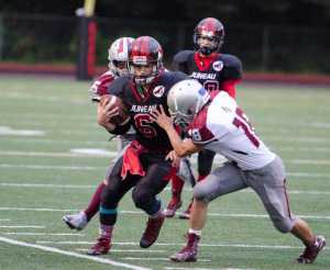 Juneau-Douglas High School's Liam Van Sickle makes contact with Ketchikan's Eli Castillero during their game Saturday at Adair Kennedy Memorial Park. JDHS won 24-20.