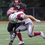 Juneau-Douglas High School's Lance Gallestes-Fiagatusa runs against Ketchikan's Nico Deguzman during their game Saturday at Adair Kennedy Memorial Park. JDHS won 24-20.