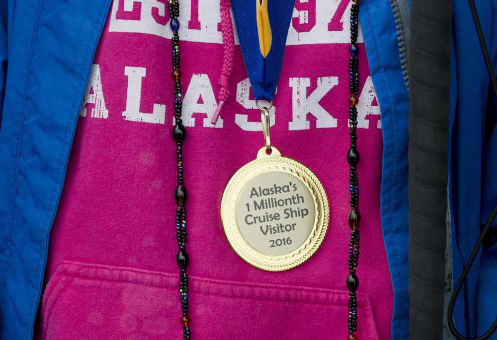 Wendy Yoisten is given a medal as the one millionth cruise ship passenger to arrive for the season in Juneau on Thursday.