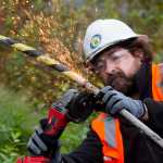 Kevin DeMont, of International Telecom, cuts through the steel armor of a fiber optic cable brought to shore in Haines for the Alaska Power and Telephone Company on Friday. The cable will bring more bandwidth to the upper Lynn Canal communities of Haines and Skagway.