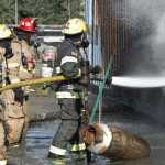 Captain Keith Walker, red helmet, watches as Capital City Fire/Rescue firefighters Travis Wolfe, right, and Shaun Rhea practice an approach on a simulated burning airplane during their yearly FAA recertification training at the Hagevig Regional Fire Training Center on Wednesday.
