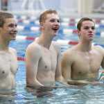 Spencer Holt, left, Christopher Ray, center, and Bergen Davis, all sophmores, take a break during Thunder Mountain High School swim team practice at the Dimond Park Aquatic Center on Wednesday.