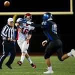 Juneau-Douglas's quarterback Maximus Wheat passes under pressure from Thunder Mountain's Steven Rosales in a cross town conference game at TMHS on Friday. TMHS won the game.