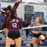 11, middle, making a solid effort to block the ball during Saturday night's varsity volleyball game against home team, the TMHS Falcons.