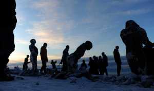 Artist Sarah Davies welcomes people to the opening of her 100Stone project on the beach at Point Woronzof in Anchorage on Dec. 5, 2015. The enormous project aims to shine a light on the struggles people have with mental health issues.