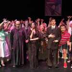 The cast of The Addams Family, a one-weekend-only musical put on by Juneau-Douglas High School. In the play, Wednesday Addams is engaged - to a boy from a "normal" family. As the Addams family hosts a meet and greet dinner between the two families, hilarity ensues.