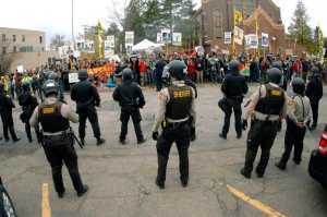 Law enforcement officers line the street in front of the Morton County Courthouse in Mandan, N.D., as Dakota Access Pipeline protesters stand on the opposite side of the street on Monday, Oct. 17, 2016. The protesters gathered in support of journalist Amy Goodman before her court hearing on a rioting charge while covering the protesters in September. A SouthCentral District judge dismissed the charge.  (Mike Mccleary/The Bismarck Tribune via AP)
