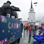 Kids hold open plastic grocery bags to catch candy hurled from parade floats during Sitka's Alaska Day parade on Tuesday, Oct. 18, 2016.