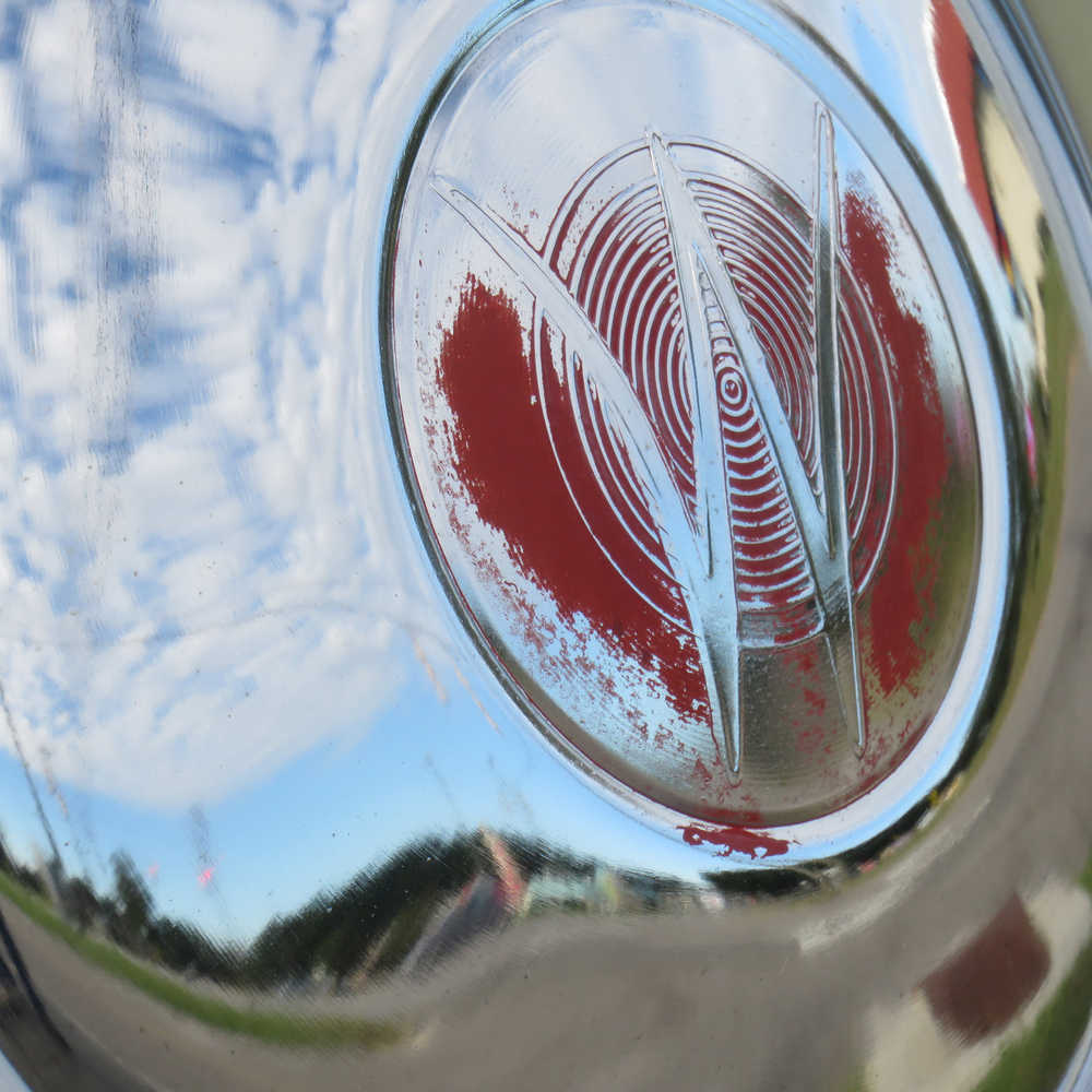 A hub cap to a 1950 Willy Jeep Roadster and the reflection off it.
