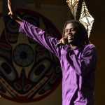 Emmanuel Jal waves his hand in the air while reciting spoken word poetry Wednesday night in the Juneau Arts and Culture Center.