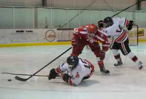 Juneau-Douglas High School's Cahal Morehouse  (15)  slides while competing for the puck with Wasilla's Alex Engan (13) as teammate Joseph Monsef (14)  scrambles to take control of the puck in Friday's game at Treadwell Ice Arena. Wasilla won 9-3.